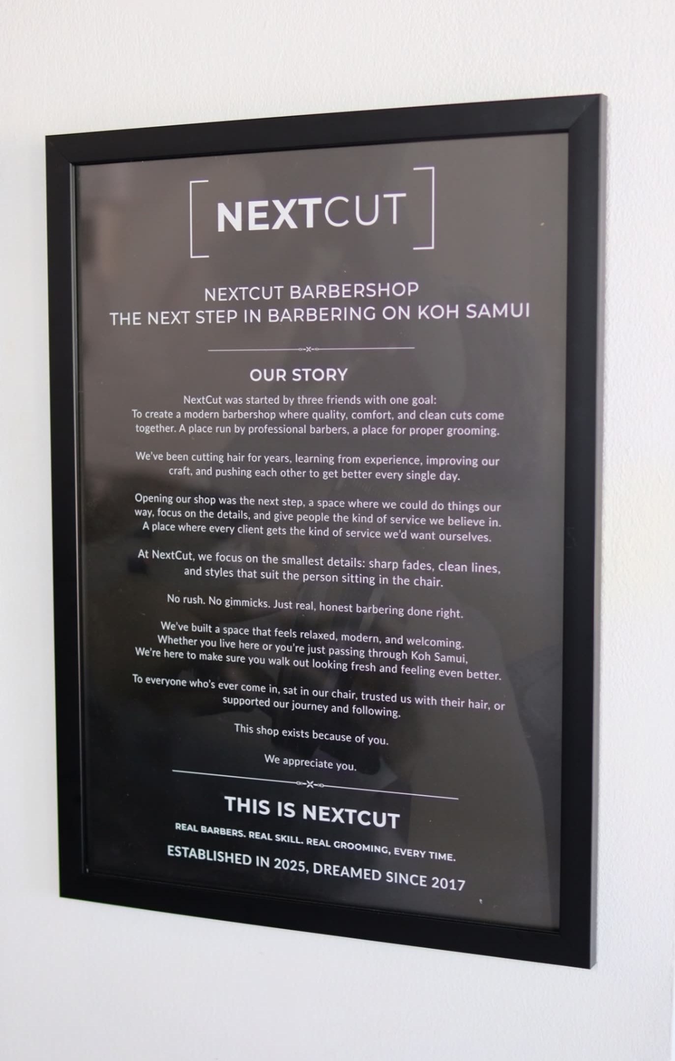 Framed NextCut Barbershop story board displayed inside the shop.